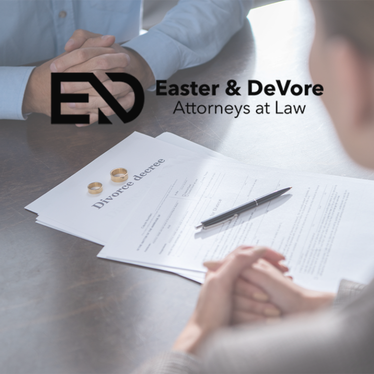 Divorce consult with decree papers, rings and pen on table; clients clasp hands, Easter & DeVore logo