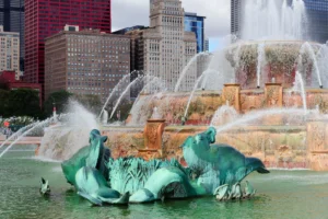 Buckingham Fountain spraying water with sea-horse sculptures and downtown Chicago buildings in the background