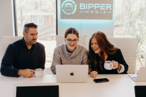 The image showcases a modern workspace featuring a laptop on a desk, symbolizing the tools essential for digital marketing professionals. This setup highlights the importance of effective communication and productivity in services like SEO and content management offered by Bipper Media.